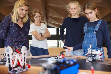 Photo of the women and two girls during an observation of a robot.