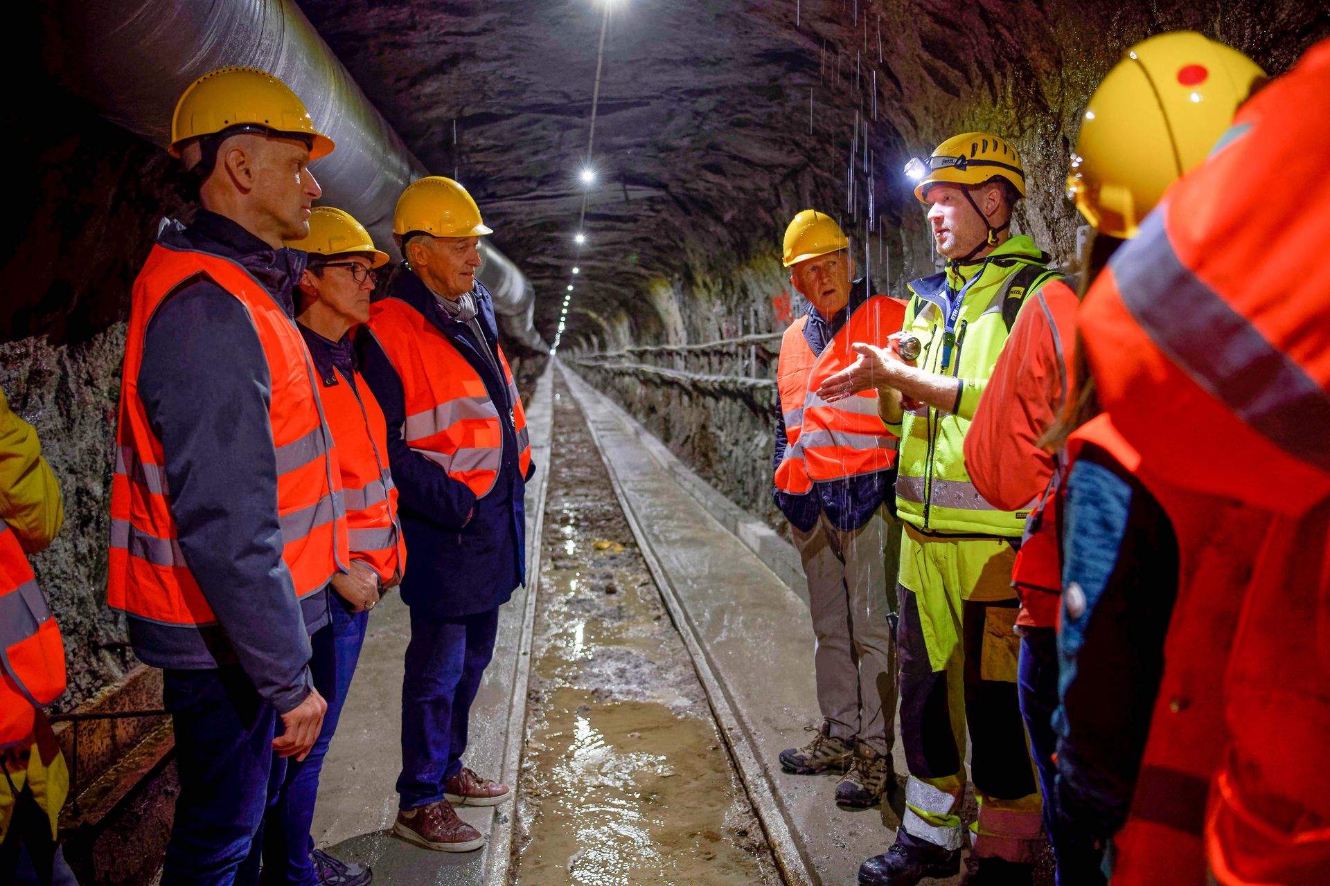 At the opening of the Bedretto Lab in May of 2019: ETH geophysicist Marian Hertrich (right, in yellow vest) gives a tour to the VIP group, taking them through a former ventilation shaft of the Matterhorn-Gotthard railway line. Photo of a tour that goes through a former ventilation shaft of the Matterhorn-Gotthard railway line.