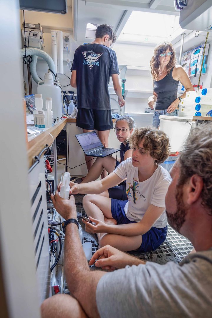 In the wet lab, Hans Slagter hands intern Sixtine Dromigny the buffer solution for the pH meter. Marine chemist Maria Calleja (back right) is responsible for coordinating work in the wet lab.