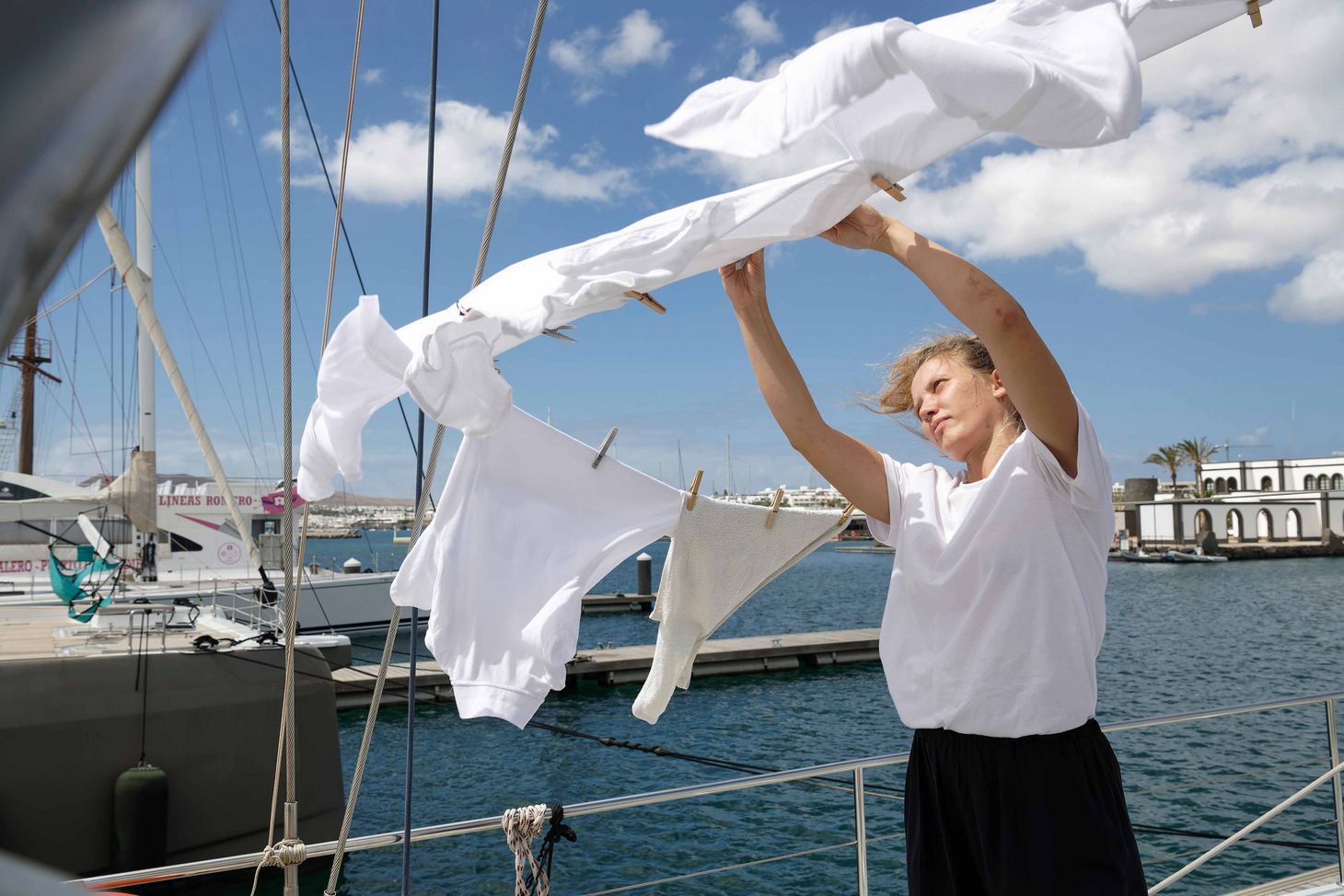 Ship steward Adeele Kuslap while hanging fresh laundry on deck.