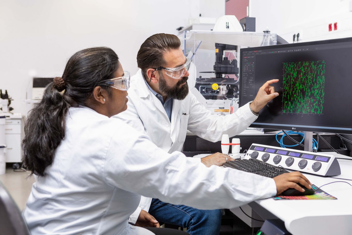 The data on the monitor show that the bio-ink growth can be steered through a scaffold made of magnetic rods—just as planned. Two researchers looking into the computer