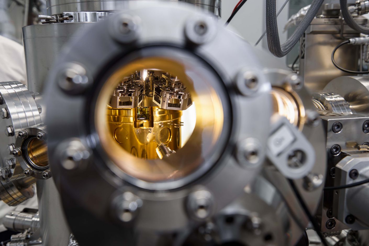 A glimpse through the peephole into the shimmering golden chamber of the scanning tunnelling microscope, where material samples are measured under vacuum conditions.