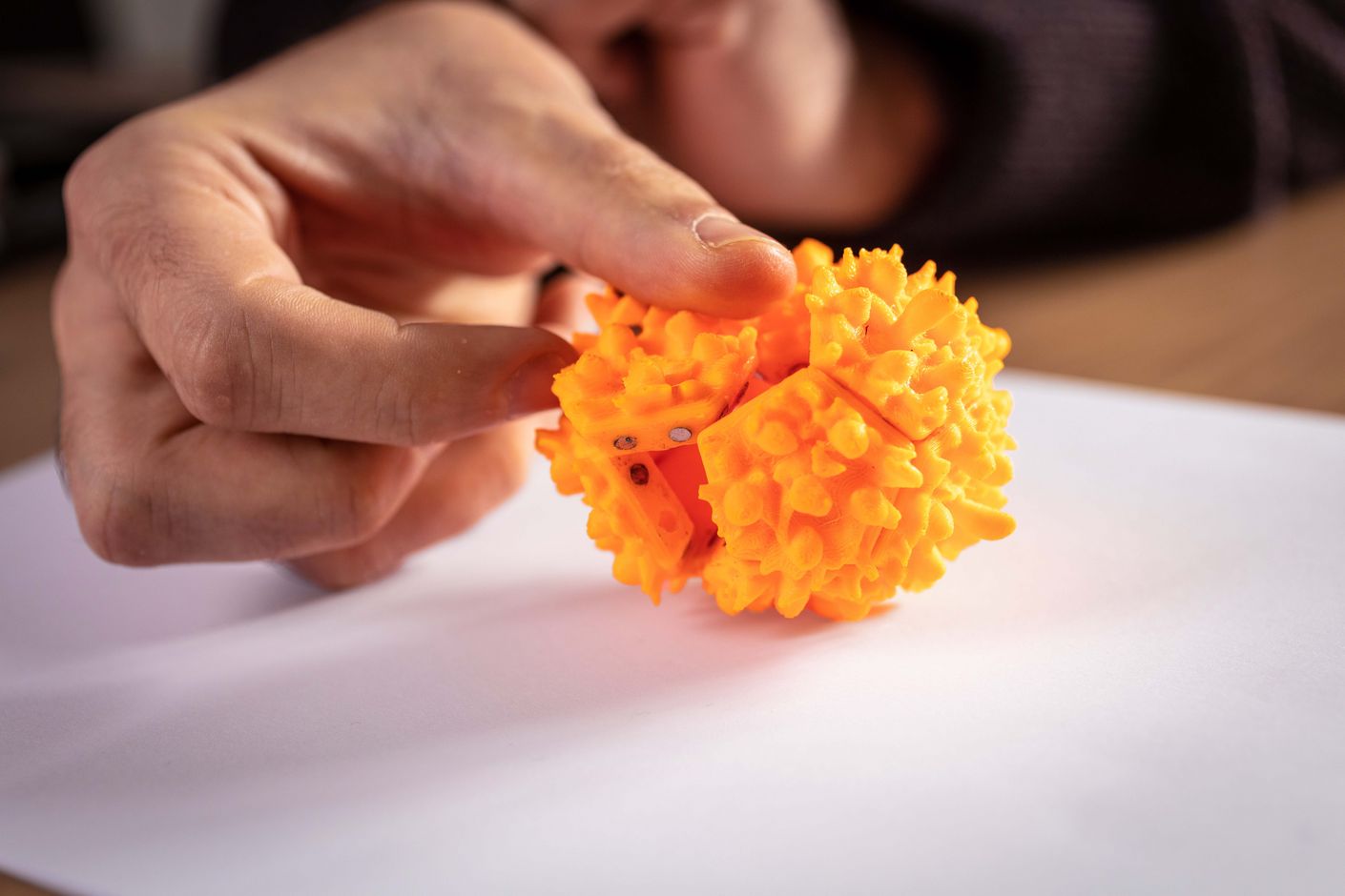 Finger zerdrückt ein Modell eines Virus